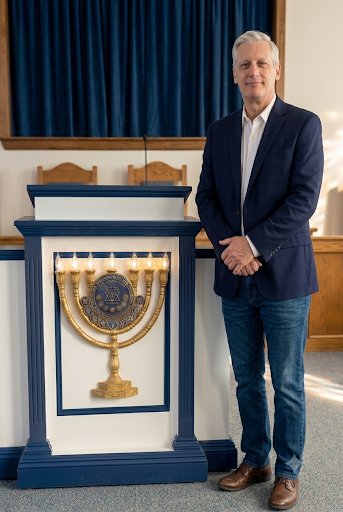 Ministry look in the church: navy blazer, open-collar shirt, jeans, and boots at the pulpit