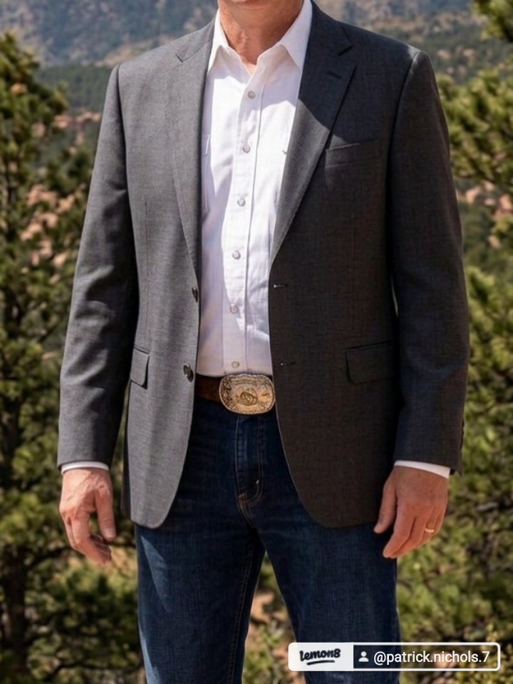 Smart western ministry style: blazer, open-collar shirt, jeans, and a signature belt buckle
